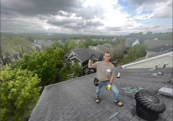 A man standing on top of a roof.