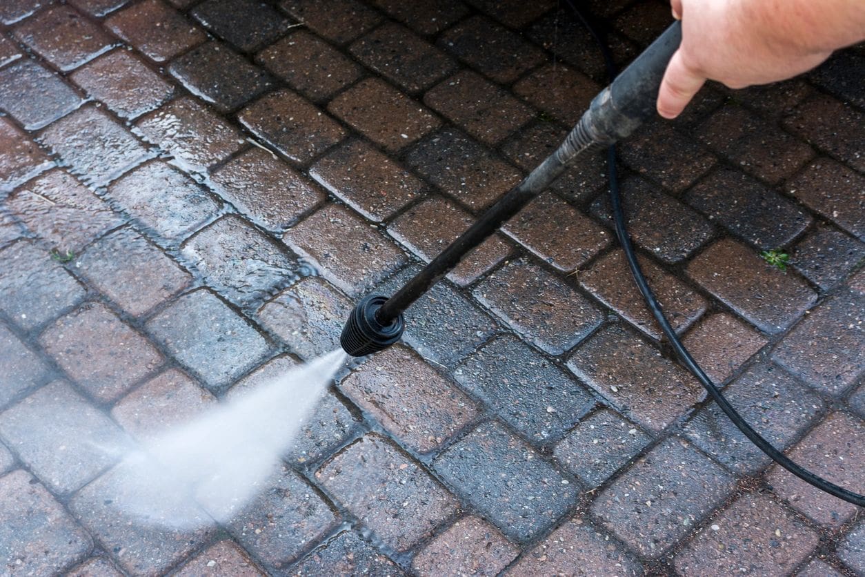 A person using a hose to clean the floor.