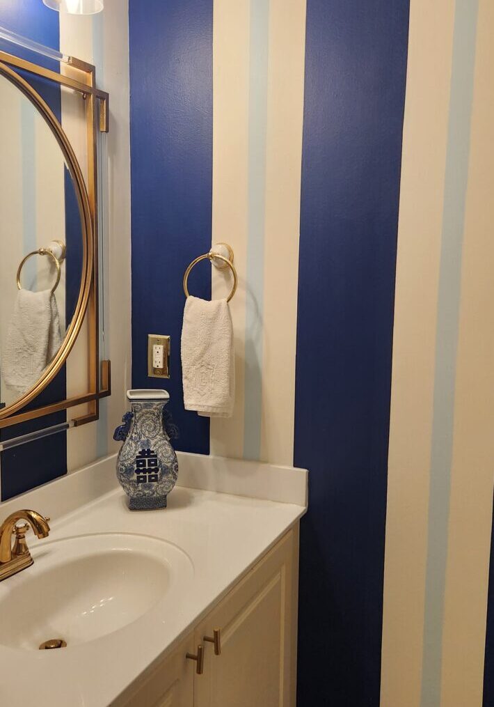 A bathroom with blue and white striped walls.